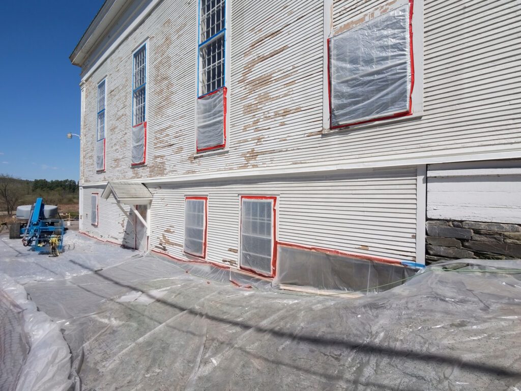 White building covered with tarp.