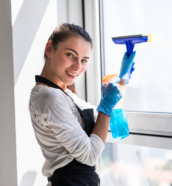 A woman uses a window cleaner to wipe a window, ensuring a clear view and a sparkling finish.