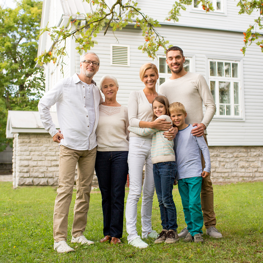 A family poses together in front of their home, showcasing a warm and inviting atmosphere.