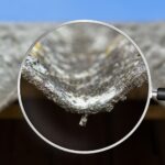 A magnifying glass examines a roof, highlighting concerns about hazardous materials and asbestos removal.